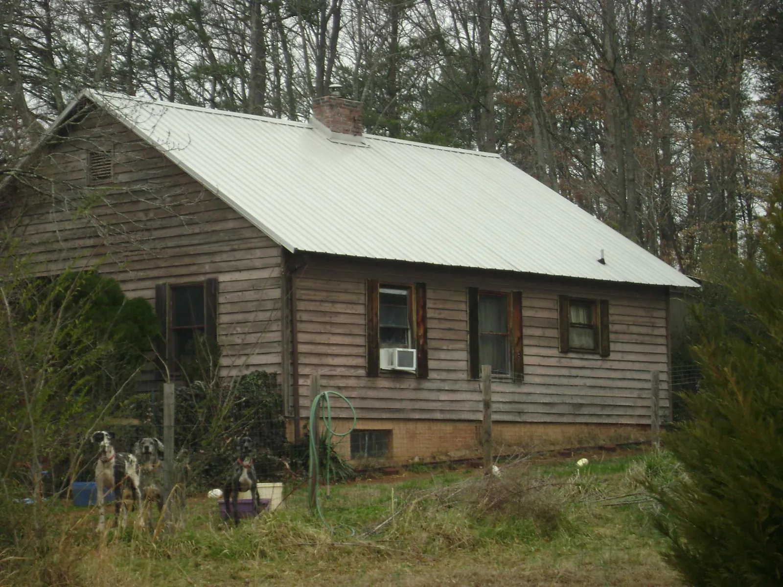 White metal roof on an old wood sided farmhouse, from a Asphalt Shingle Roof Repair job in Clayton